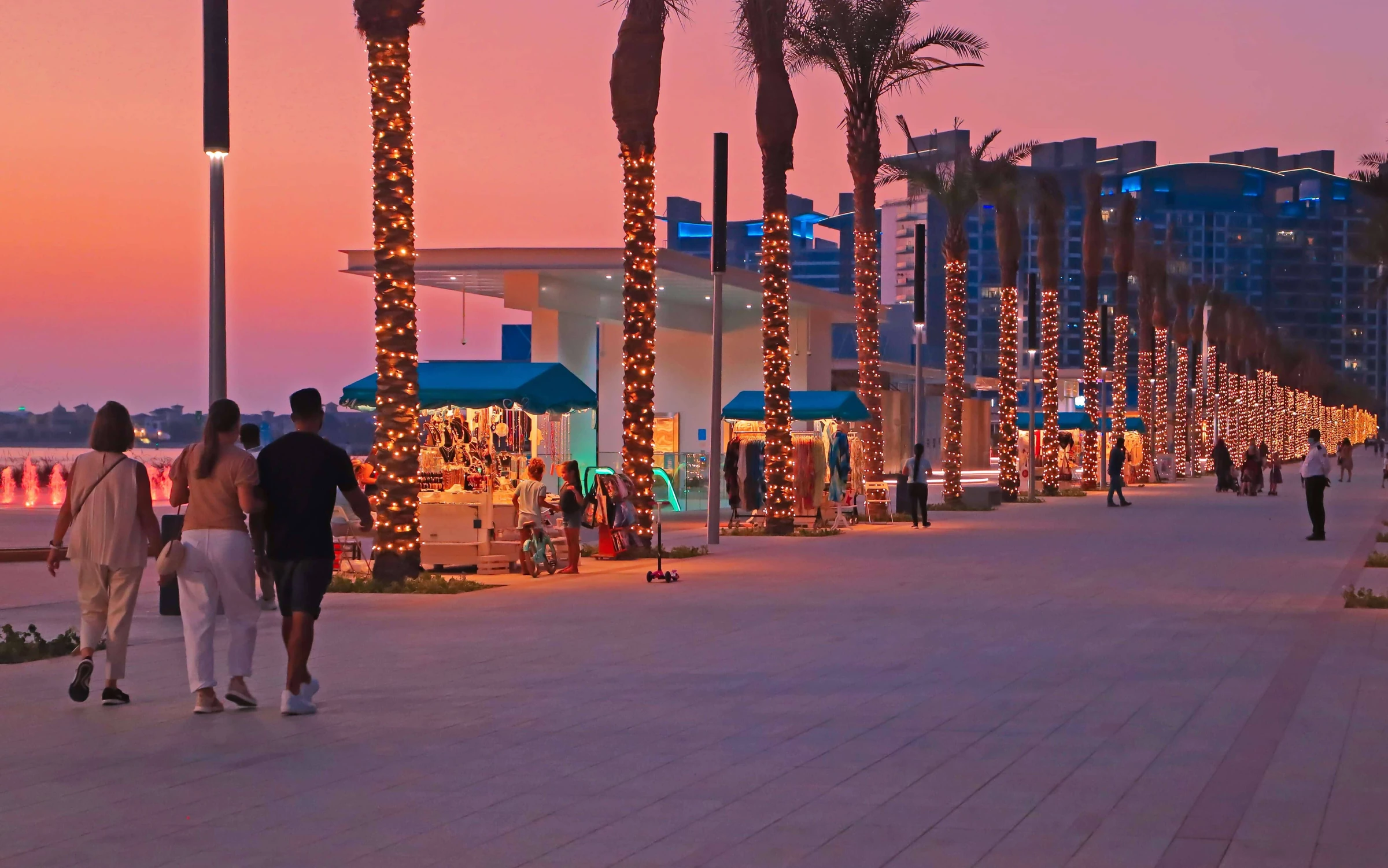 Palm West Beach promenade and beachfront restaurants at sunset.