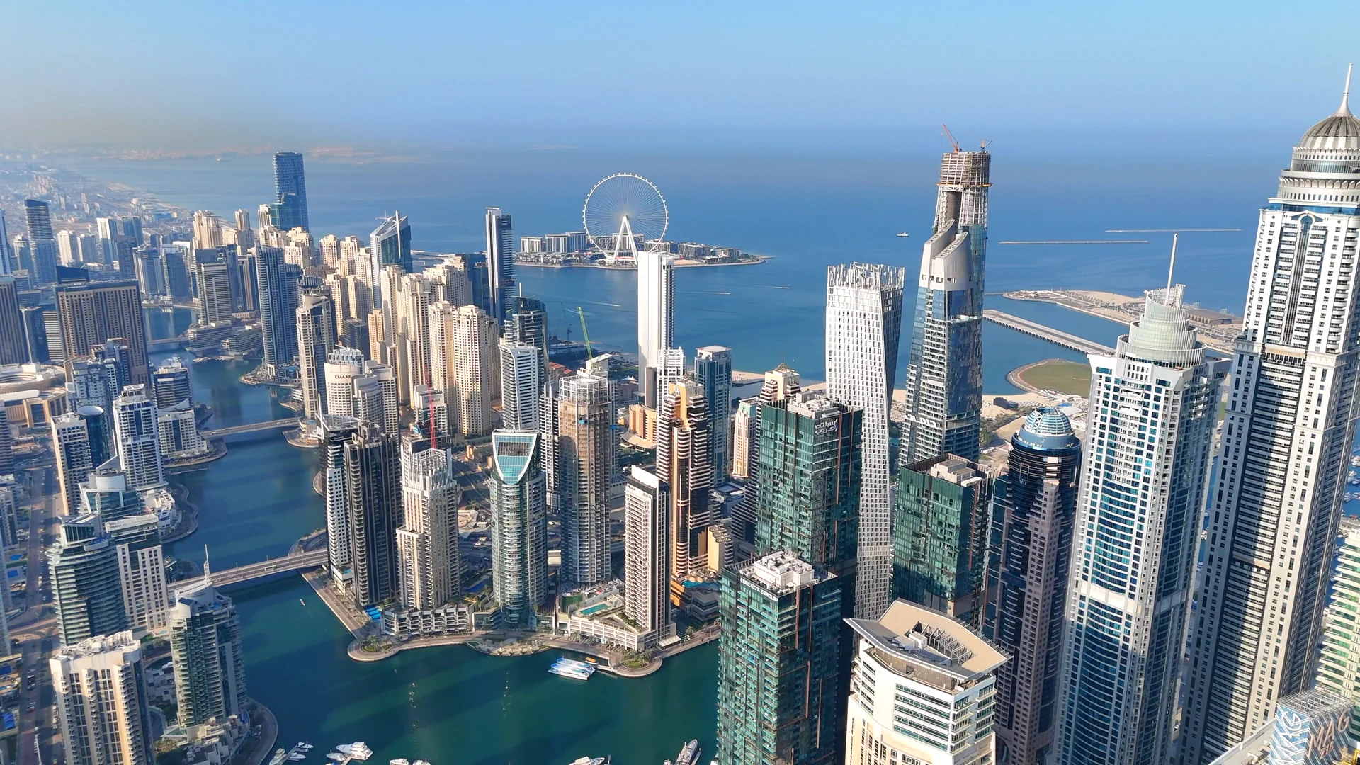 Aerial view of Dubai Marina towers with Bluewaters Island and Ain Dubai beyond